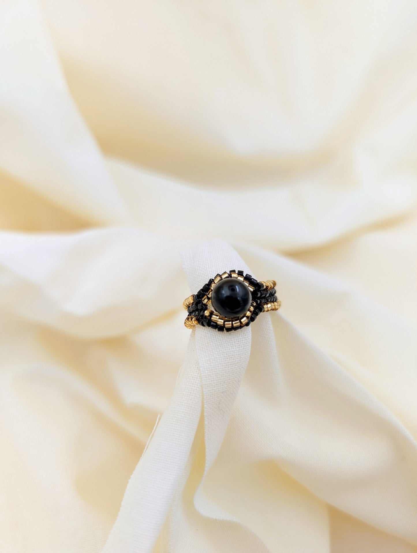 Bague artisanale Icarus, tissée en perles Miyuki et obsidienne dorée